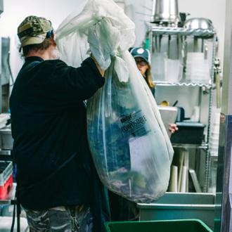 Employee takes out compostable waste